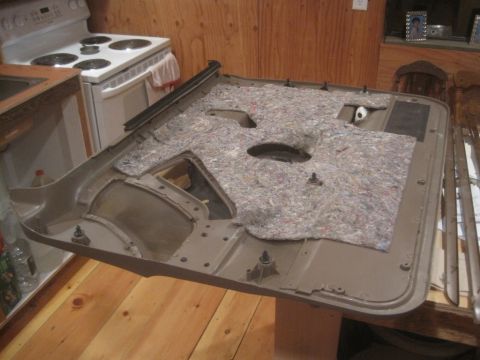 1993 Ford Bronco - A tan car door panel with insulation is displayed indoors.