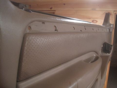 1993 Ford Bronco - Interior door panel with a perforated section and a handle, showing mounting holes.