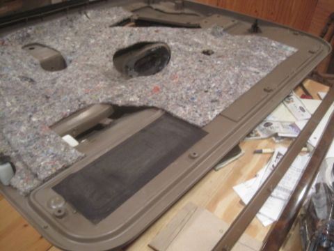 1993 Ford Bronco - Disassembled car door panel showing interior insulation and speaker mounting area.