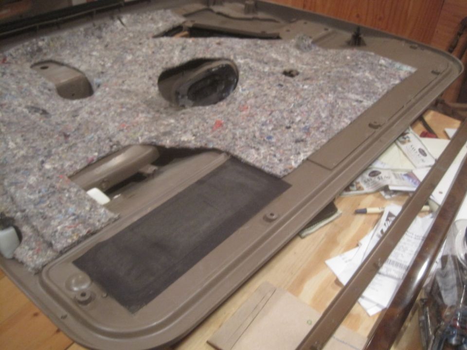 Disassembled car door panel with insulation and speaker cutout