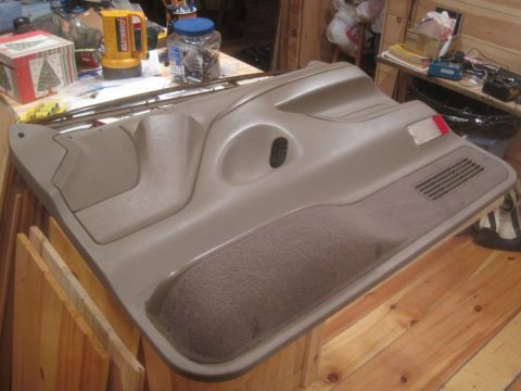 1993 Ford Bronco - A vehicle door panel is shown resting on a wooden surface, with various items in the background.