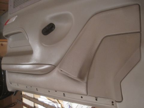 1993 Ford Bronco - Interior door panel of a vehicle, showing textured inserts and a speaker grille.