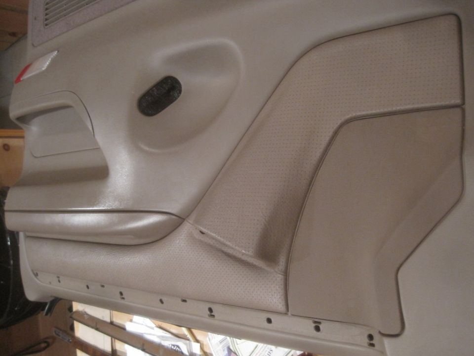 Tan car door panel with textured insert and black speaker grille