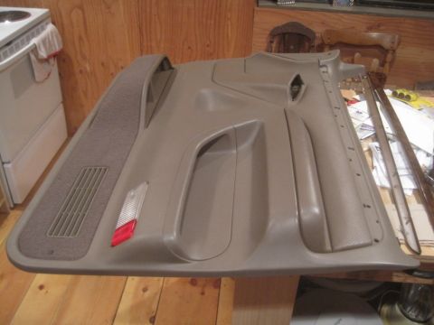 1993 Ford Bronco - Interior door panel with integrated speaker grille and a red reflector is shown.