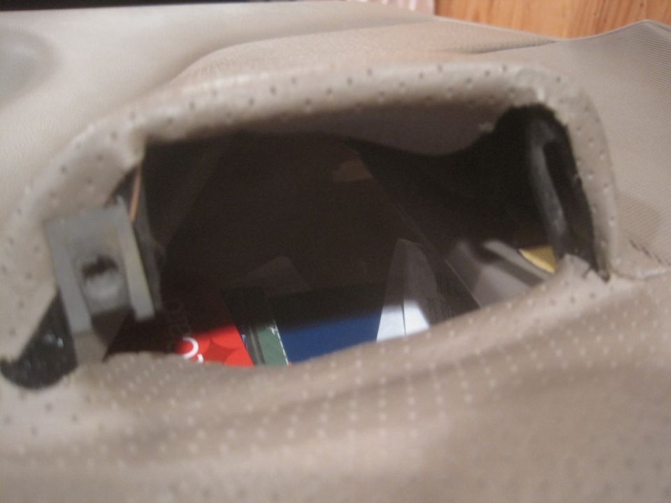 Close-up of a car's interior door panel showing an open storage compartment with some items inside