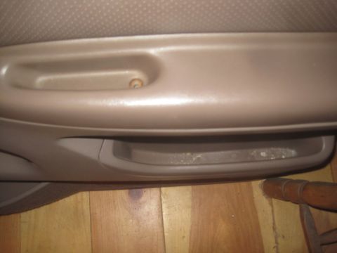 1993 Ford Bronco - Close-up of a car's interior door panel, showing the pull handle and a storage compartment.