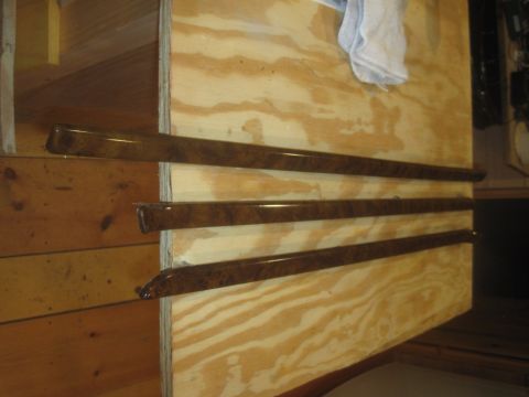 1993 Ford Bronco - Four wood grain interior trim pieces are displayed on a plywood backing.