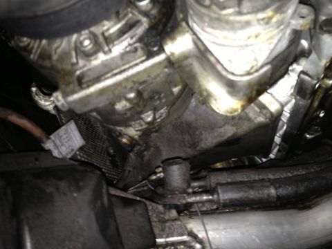 1999 BMW 5 Series - Close-up of an engine bay showing signs of an oil leak and various components.