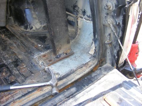1996 Ford Bronco - This photo shows the interior of a vehicle undergoing body repair, focusing on rusted metal and welding work.