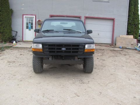 1996 Ford Bronco - Front view of a black Ford Bronco with a dark grille and amber turn signals.