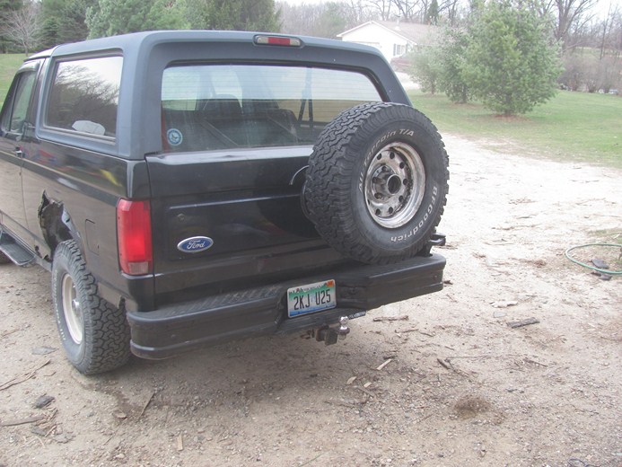 Black 1996 Ford Bronco rear view with spare tire on carrier, license plate 2KJ U25
