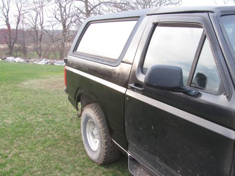 1996 Ford Bronco - Side view of a 1996 Ford Bronco, showing its body lines and rear quarter panel.
