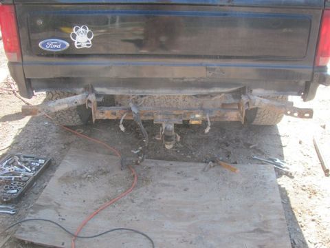 1996 Ford Bronco - Rear view of a black 1996 Ford Bronco with its bumper removed, revealing a rusty frame and hitch.