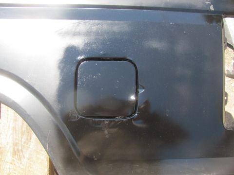 1996 Ford Bronco - Close-up of a black fuel door on a vehicle's rear quarter panel, with SuperMotors.net watermark.