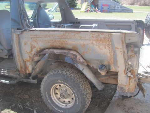 1996 Ford Bronco - This heavily rusted 1992 Ford Bronco shows extensive body damage and a missing fender.
