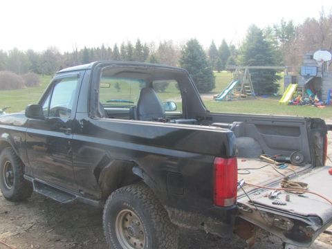 1996 Ford Bronco - This black Ford Bronco appears to be undergoing some work, with tools visible in the open rear.