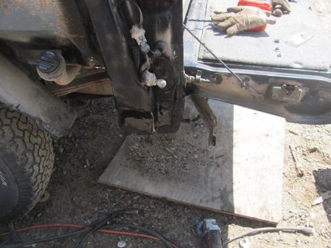 1996 Ford Bronco - Close-up of the rear door hinge area of a 1996 Ford Bronco, with tools and a tire visible.