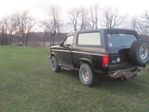 1996 Ford Bronco - This black Ford Bronco is seen from a rear three-quarter angle in an outdoor setting.