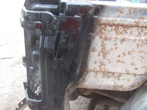 1996 Ford Bronco - This image shows a section of a vehicle's frame with significant rust and black paint applied over it.