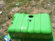 1996 Ford Bronco - A freshly painted green fuel tank sits outdoors on the grass.