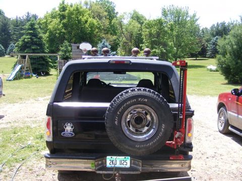 1996 Ford Bronco - The rear of a black 1996 Ford Bronco is shown, equipped with a spare tire and a high-lift jack.