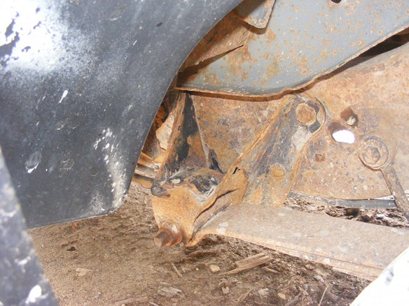 Rusted suspension parts under a vehicle, showing significant corrosion