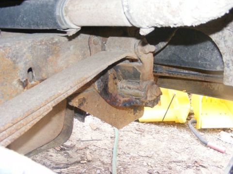 1996 Ford Bronco - Close-up view of heavily rusted leaf spring and suspension parts, showing wear and tear.