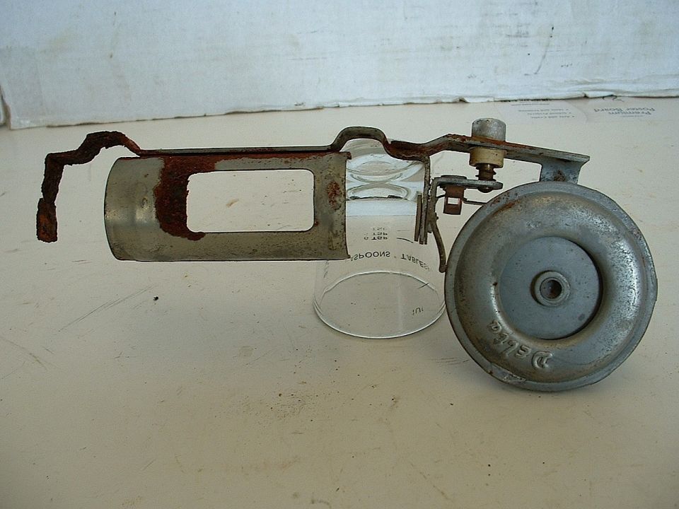 Rusted metal assembly with glass cylinder and Delco horn