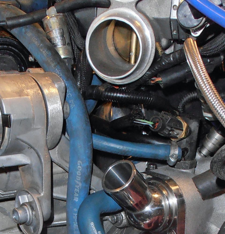 Close-up of engine throttle body, blue Goodyear hoses and braided lines in engine bay