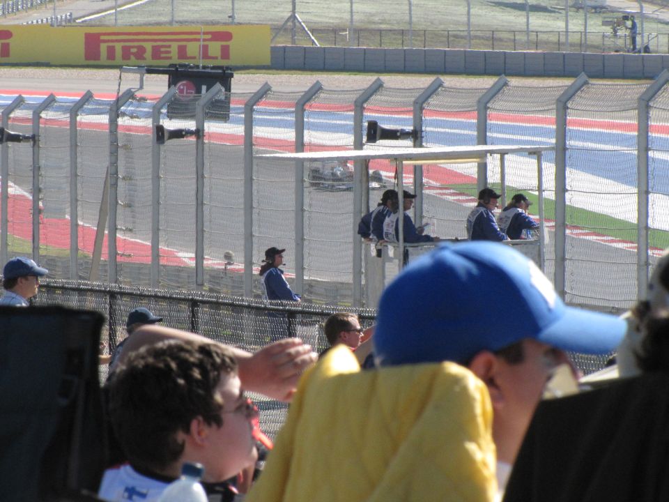 Race track with Pirelli banner and spectators behind fences
