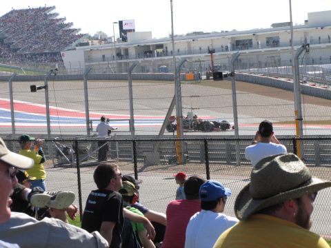 2006 BMW 5 Series - Spectators watch a Formula 1 race car during a competition at a circuit.