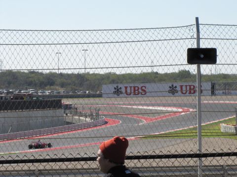 2006 BMW 5 Series - A race track scene with a lone car on the course and advertising banners in the distance.