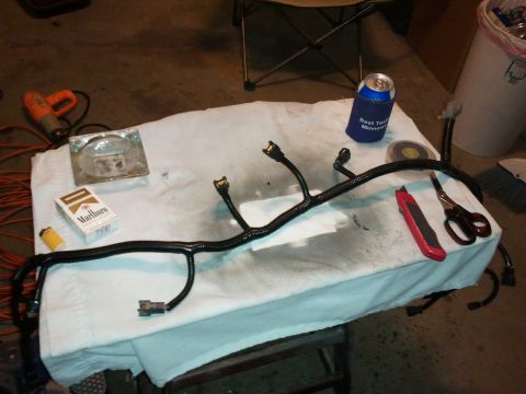 1990 Ford Bronco - A vehicle wiring harness is laid out on a cloth with various tools and smoking supplies.