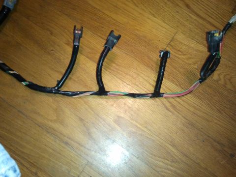 1990 Ford Bronco - A close-up view of a vehicle's wiring harness, showing various connectors and wire colors.