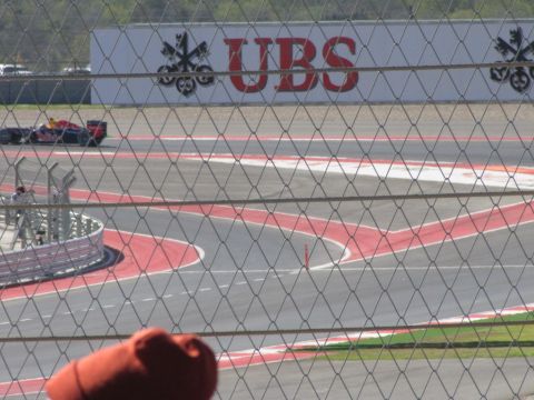 2006 BMW 5 Series - A racing car navigates a turn at a circuit with UBS branding visible in the background.