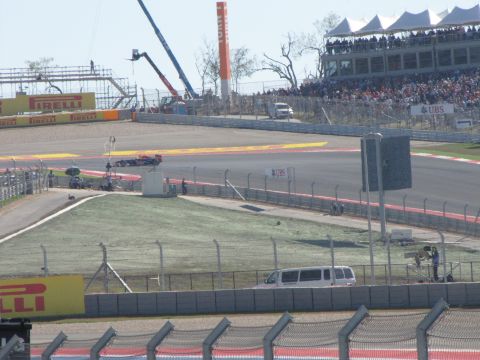 2006 BMW 5 Series - A white limousine is visible on the side of a race track, with a crowd of spectators in the stands.