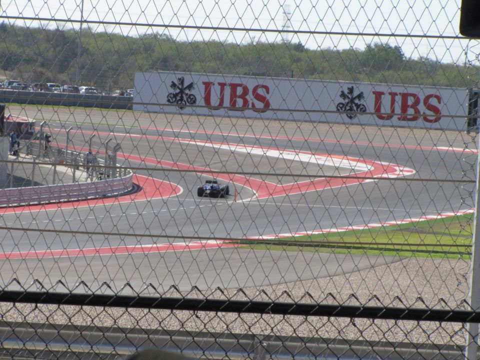 Race car on a track with UBS signage in background