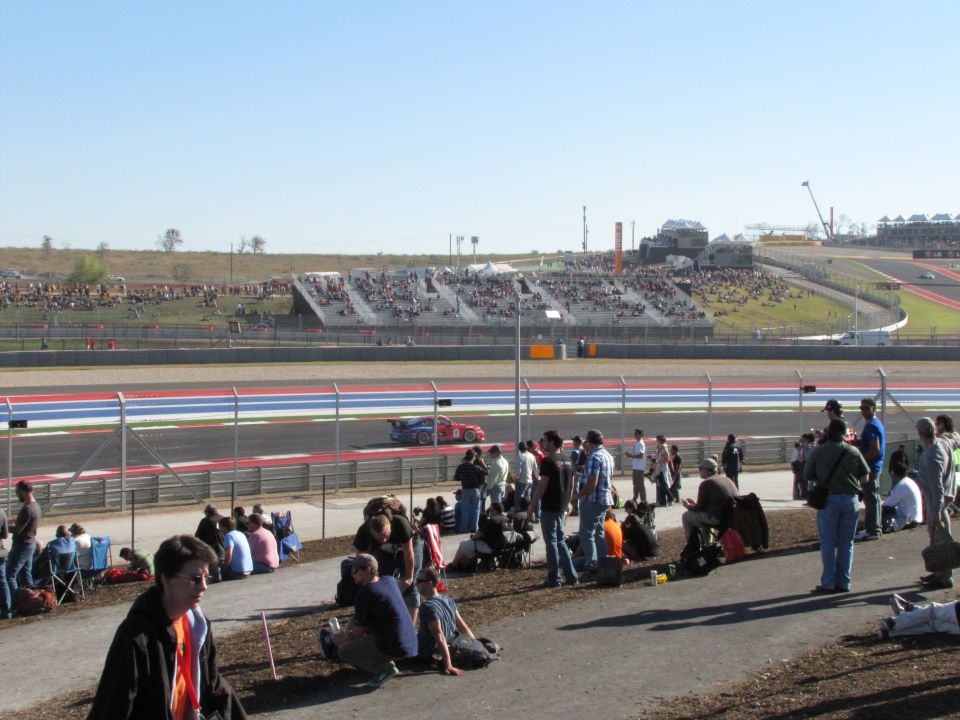Red race car on track with spectators in the background