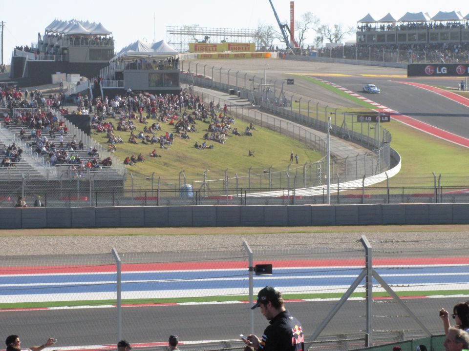 Race car on track with spectators in grandstands at Circuit of the Americas