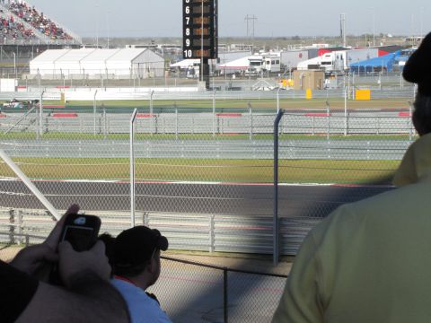 2006 BMW 5 Series - A view of a race track with spectators in the stands and various support structures in the background.