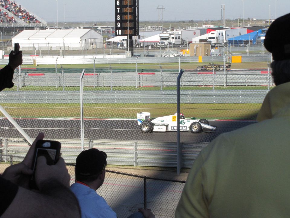 White race car with green and blue accents on track