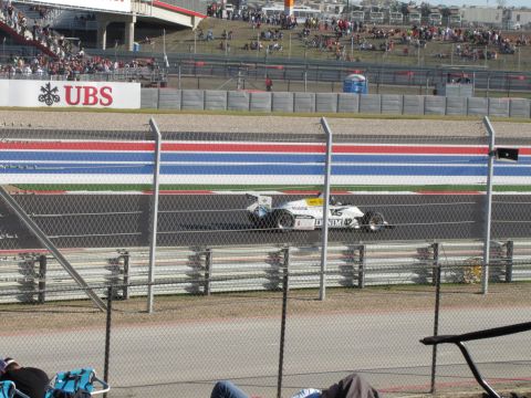2006 BMW 5 Series - Race car on track at Circuit of the Americas with spectators in the stands.