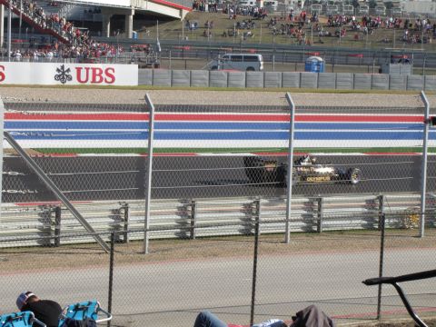 2006 BMW 5 Series - A Formula 1 race car competes on a track, with spectators visible in the grandstands.