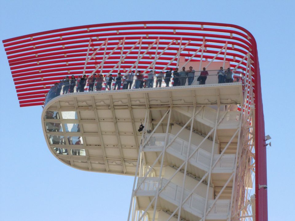Observation tower with red and white striped overhang and people on viewing platform
