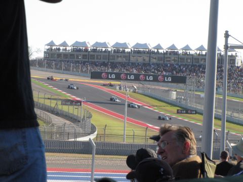 2006 BMW 5 Series - Race cars compete on a track with grandstands full of spectators.