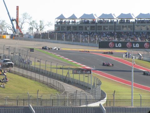 2006 BMW 5 Series - Race cars compete on a circuit with spectators watching from the grandstands.