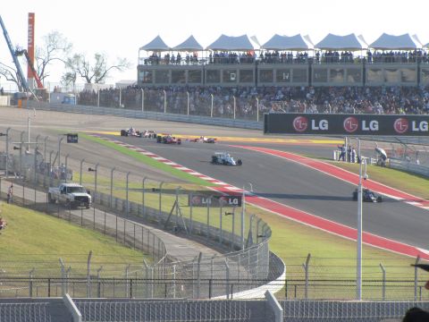 2006 BMW 5 Series - A Formula 1 race is underway at a circuit with grandstands filled with spectators and prominent LG branding.