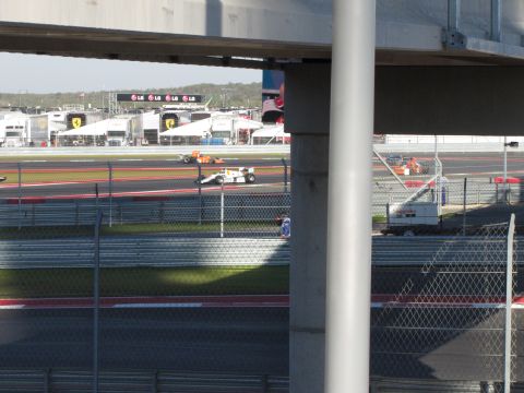 2006 BMW 5 Series - Race cars compete on a track with pit lane structures visible in the background.
