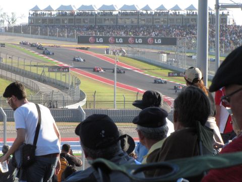 2006 BMW 5 Series - Race cars compete on a track with grandstands full of spectators.
