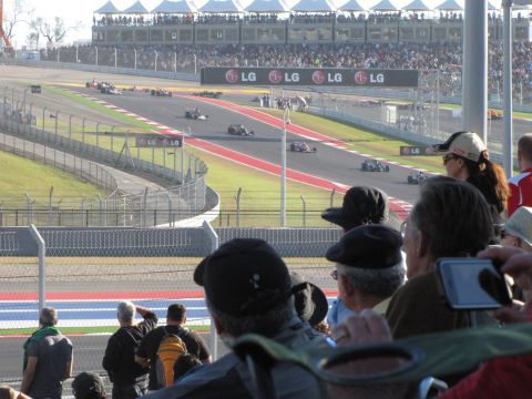 2006 BMW 5 Series - Race cars compete on a track with grandstands full of spectators.